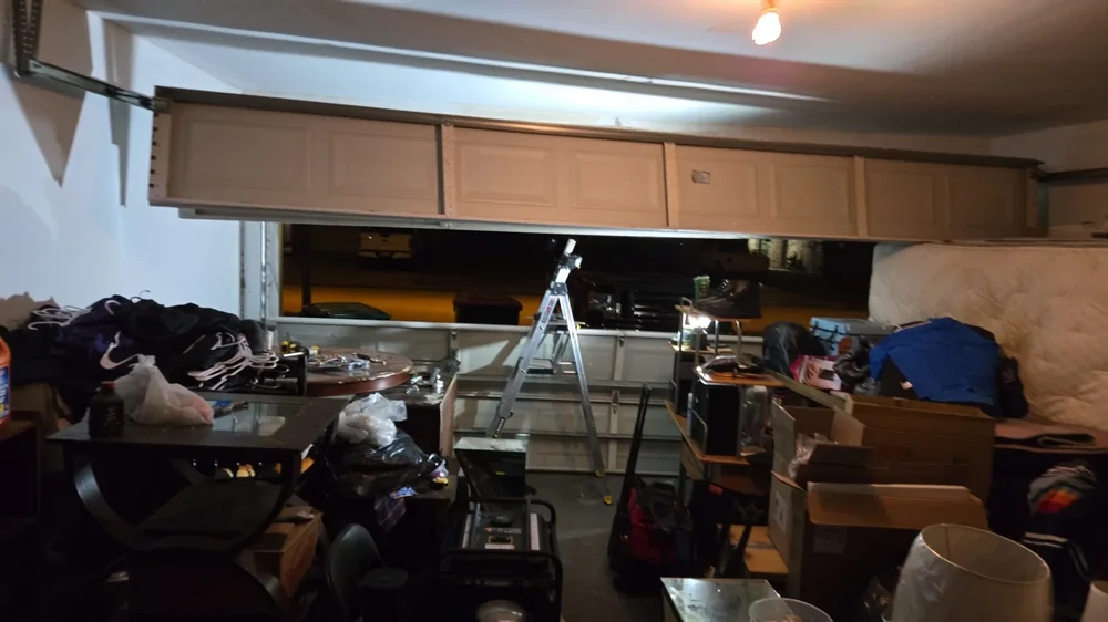 Wide interior garage repair scene with door overhead and work equipment